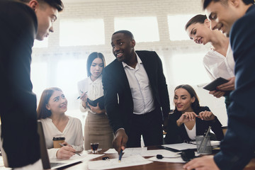 A group of young people holds brainstorming in the office.