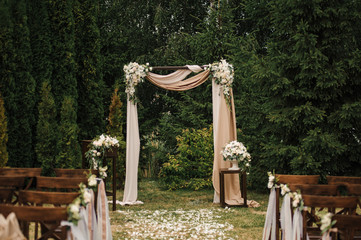 Very beautiful outside ceremony. classical wedding in forest. The arch is wooden. White flowers....