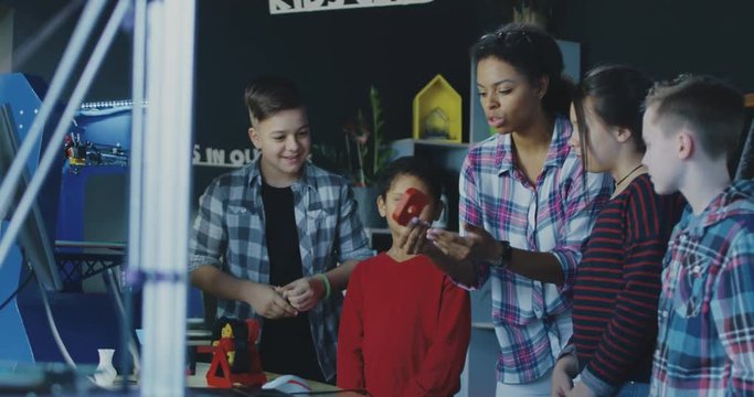 Black teacher with group of children having class about three dimensional technologies. Movement 4K shot on Red cinema camera.
