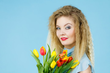 Obraz na płótnie Canvas Pretty woman with red yellow tulips bunch