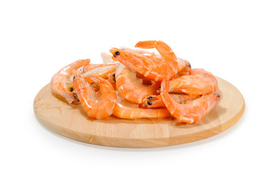 Many shrimps in ice shell on round wooden plank on white background