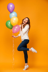 Fototapeta na wymiar Excited young woman holding balloons.