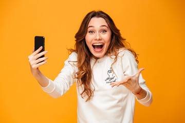 Excited screaming young woman using mobile phone. - obrazy, fototapety, plakaty