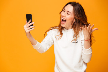 Excited emotional young woman make selfie by mobile phone.