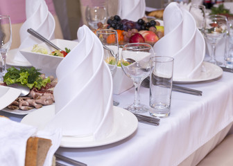 table decorations, napkin folded in a pyramid, glasses, dishes, meals, food