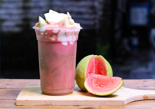 Milkshake with guava pieces, in  plastic cup, delicious and fresh.