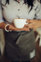 Female waitress holding cup of coffee