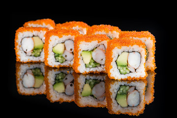 Traditional Japanese cuisine. Tasty sushi rolls with rice, cream cheese, shrimps, avocado on dark background