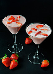 Strawberry milkshake and fruits on dark background