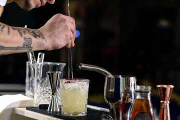 Unidentified barman preparing cocktail at the bar counter