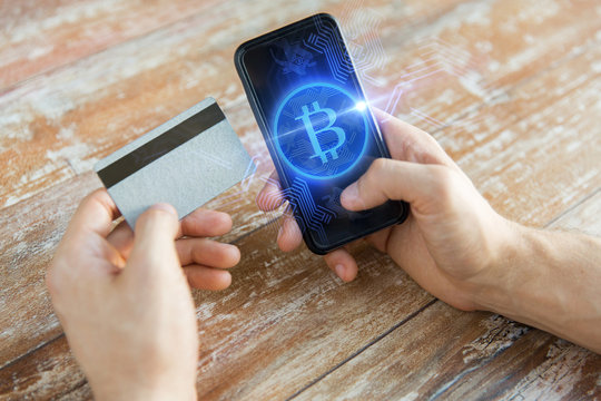 close up of bitcoin on smartphone and credit card