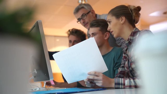 Group of students in computing class with teacher