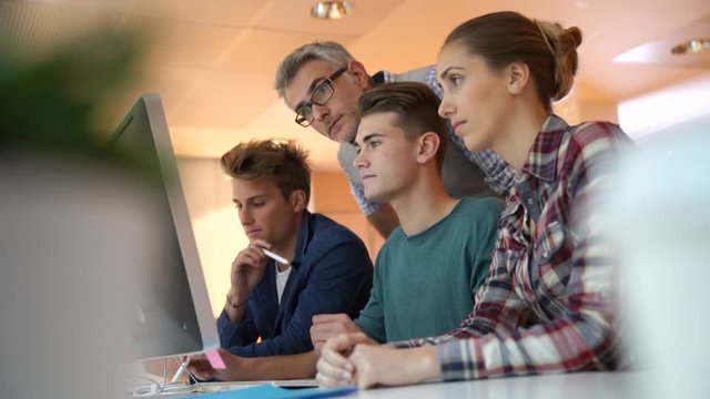 Group of students in computing class with teacher