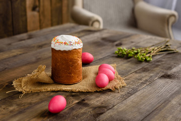 Easter cake and colorful eggs on a wooden table. It can be used as a background