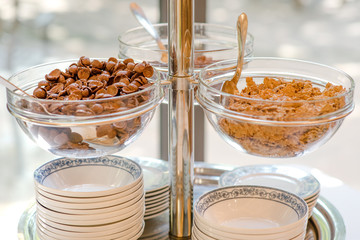 Corn flakes and chocolate cereals in a glass bowl