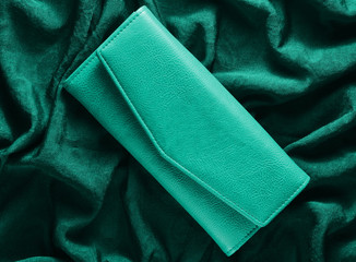 Fashionable women's purse on a green silk background.