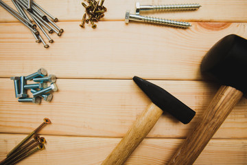 Repair carpenter tools: rubber hummer and nails on old wooden background, top view, copy space