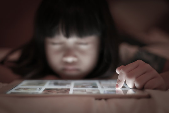 Child uses tablet internet online with scare emotion.