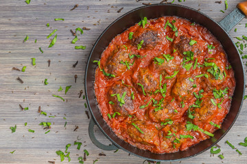 Greek soutzoukakia the patties in tomato sauce in the pan. Close up. The view from the top....