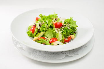 Dietary salad with seeds on a white plate