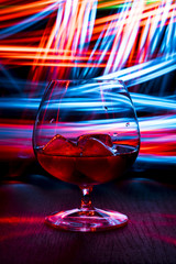 Glass of whiskey on the table. Dark background with bokeh effect.