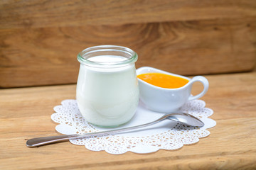 Milk can and saucepan with honey, spoon