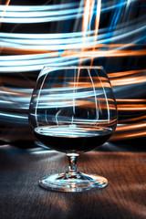 A glass of cognac on bright background with bokeh effect.