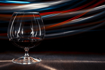 A glass of cognac on the table. Bokeh effect.