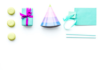 Birthday party accessories. Gift box, paper bag, party hat on white background top view copy space