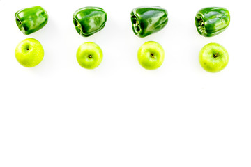 Green vegetables pattern. Shiny bell pepper and fresh apple on white background top view copy space
