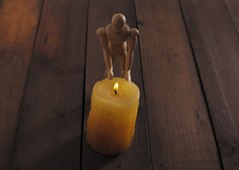 wooden dummy for drawing warm hands from fire from a candle