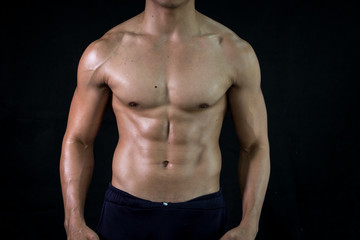 Close up bodybuilder muscular beautiful body on black background