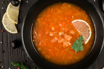 Soup with lemon on a dark background