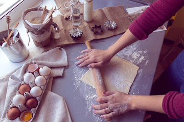 Female hands roll out the dough