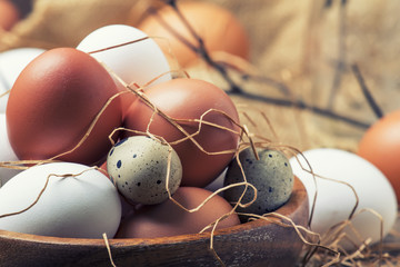 Easter composition with colorful chicken and quail eggs in rustic style, vintage wooden background,...