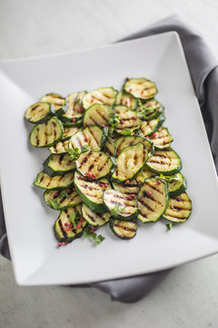Zucchini. Grilled zucchini with red spice on white plate