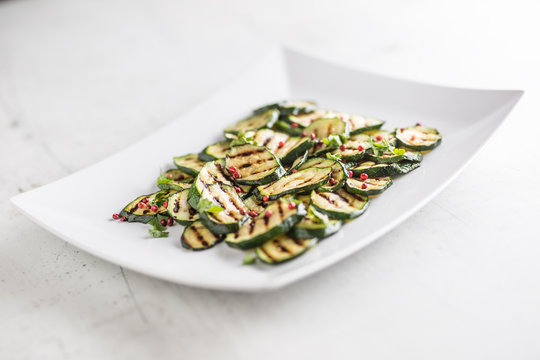 Zucchini. Grilled zucchini with red spice on white plate