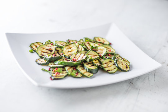 Zucchini. Grilled zucchini with red spice on white plate