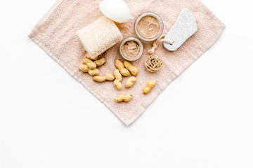 Obraz na płótnie Canvas Natural cosmetics for skin care. Body scrub with peanut. White background top view copy space