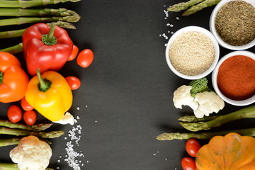 Fresh Colorful Vegetables ingredients for tasty vegan and healthy cooking  on black background, top view, frame. 