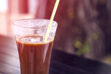traditional Vietnamese coffee with condensed milk in a tall glass near the swimming pool
