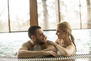 Loving couple relaxing in the pool at spa