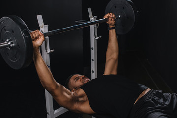 Fototapeta na wymiar muscular young african american sportsman lifting barbell