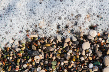 multi-colored pebbles on the beach, washed by waves