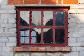 Old red window on a white brick wall