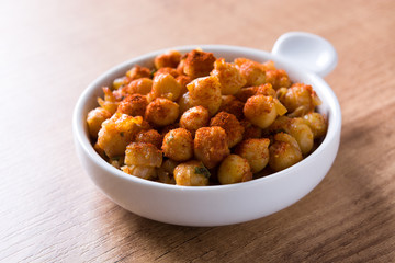 Fried spicy chickpeas on wooden table