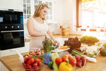 Pregnant woman making a meal in kitchen