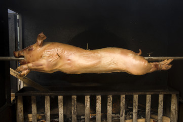 Baking a piglet on fire. Piglet on the roasting-jack
