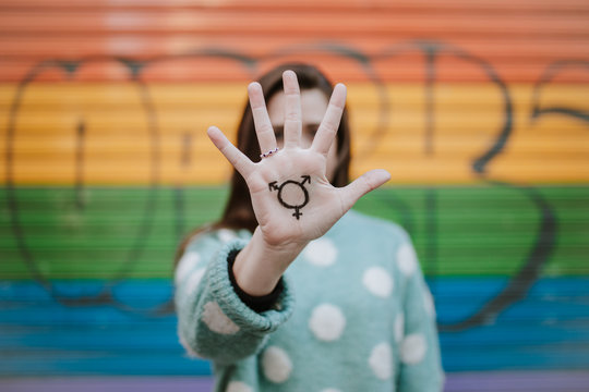 Woman showing homosexual symbol on hand outdoors