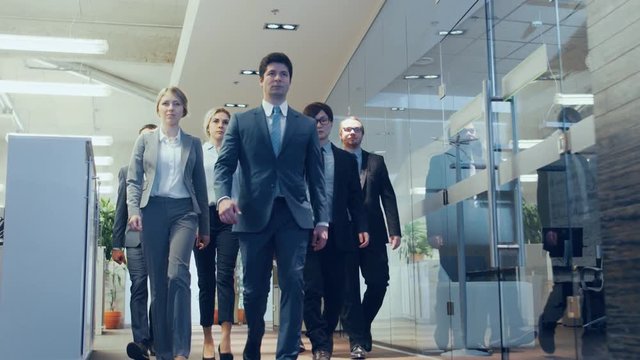 Diverse Team of Delegates/ Lawyers Confidently Marching Through the Corporate Building Hallway. Multicultural Crowd Of Resolute Business People in Stylish Marble and Glass Offices. 